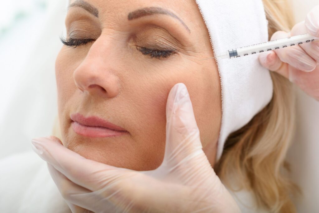 a patient receiving a Botox injection in a clinical setting, showing the procedure being performed by a professional.