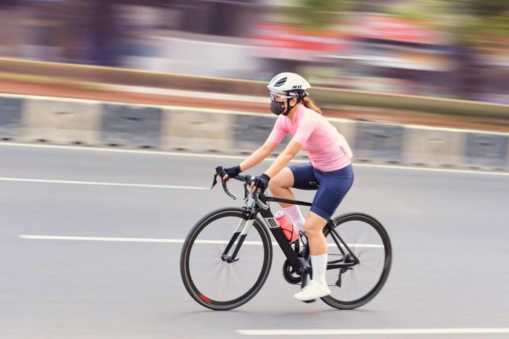 An athlete cycling, showcasing healthy legs and vein care.